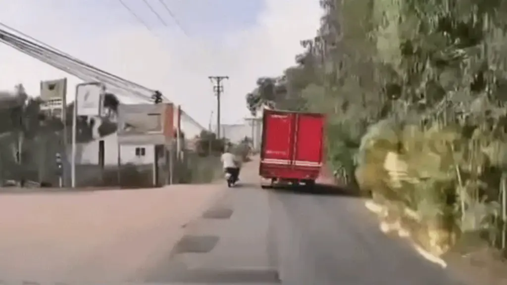 Người đi xe máy trượt ngã vào gầm xe tải